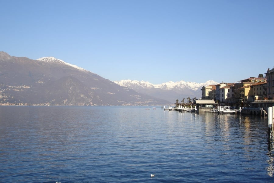 Il lungolago d'inverno — Le Alpi innevate all'orizzonte oltre le acque del lago