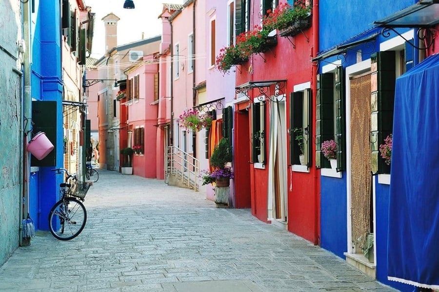 Una calle di Burano — Biciclette, fiori e bucato tra le case a schiera