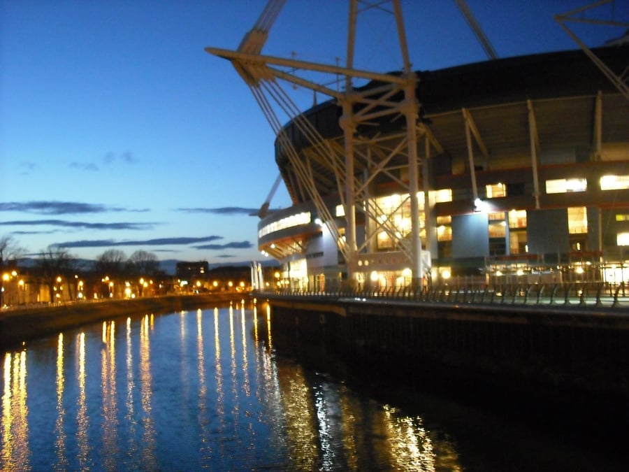 Il Principality Stadium al crepuscolo — Le luci dello stadio nazionale si riflettono nel fiume Taff