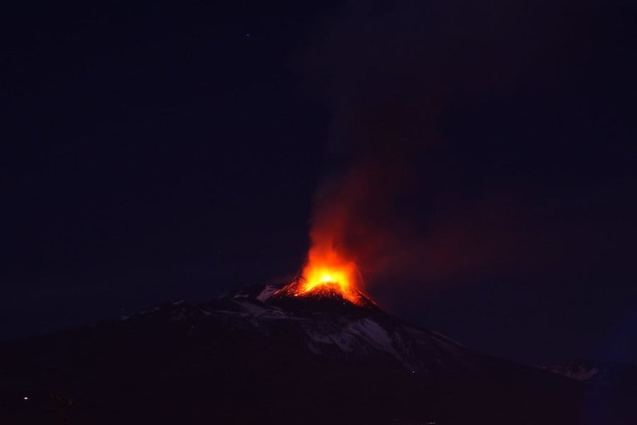 L'Etna di notte — Il vulcano che sovrasta la città si accende di lava