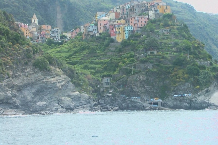 Il promontorio visto dal mare — Le case pastello incorniciate dai terrazzamenti verdi
