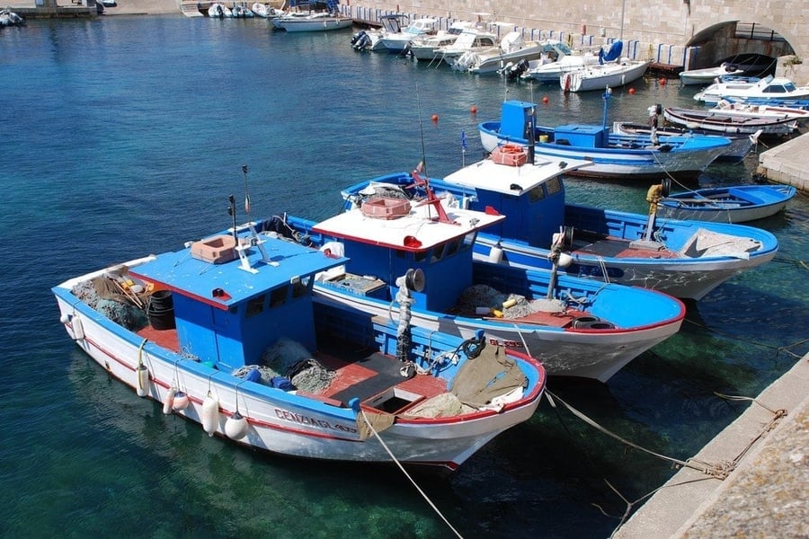 Le barche dei pescatori — Imbarcazioni colorate ormeggiate nell'acqua turchese del porto