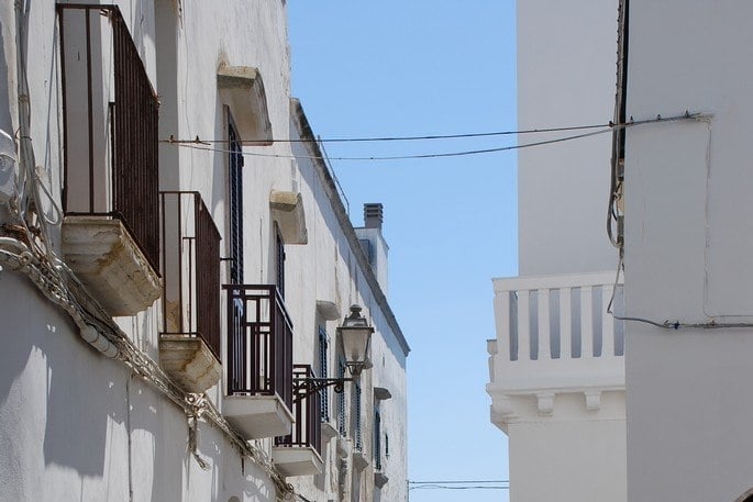 Un vicolo del borgo antico — Case bianche che si aprono all'improvviso sul mare