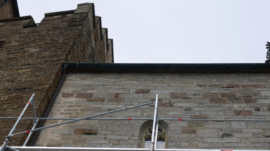 Un cantiere nelle mura — Il profilo a gradoni di una torre e il muro di un edificio vicino, con l'impalcatura di un restauro