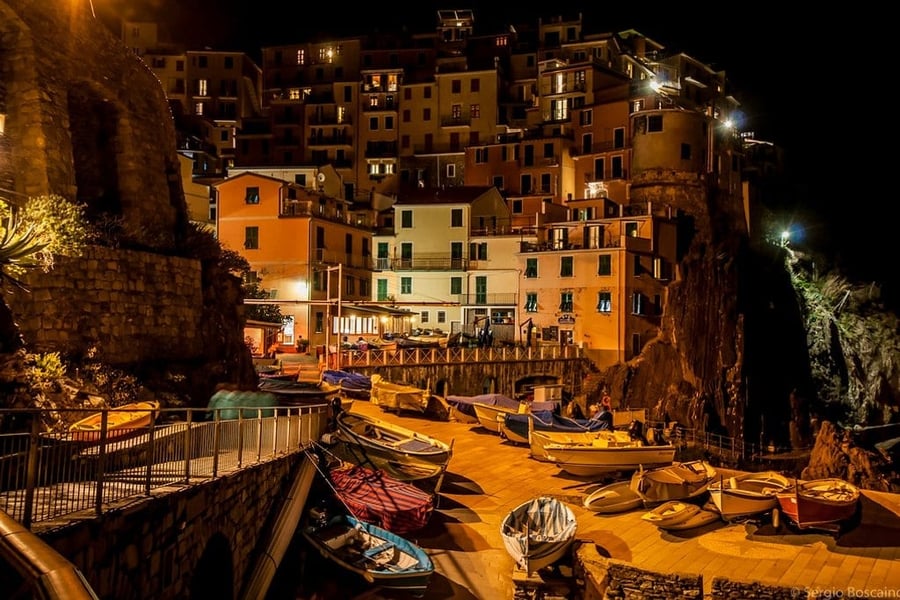 Il porticciolo di notte — Le barche tirate in secca sotto le case illuminate