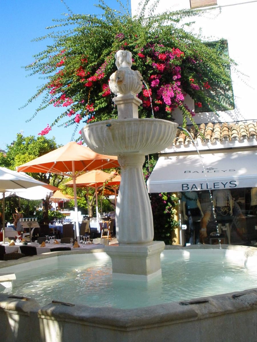 La fontana di Plaza de los Naranjos — Acqua fresca sotto la bouganville tra i caffè all'aperto