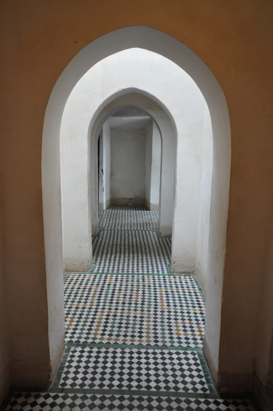 Bahia Palace — A sequence of white arches over a floor of zellige tiles