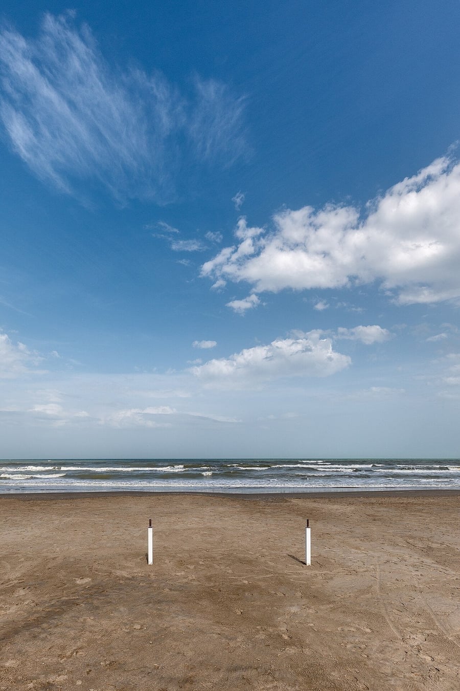 La spiaggia di Milano Marittima — Sabbia dorata sotto un cielo di nuvole bianche
