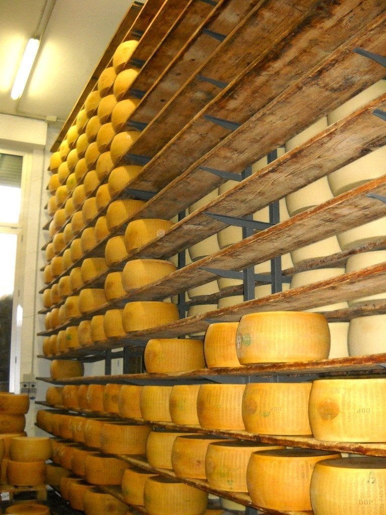 Il magazzino di stagionatura — Migliaia di forme di Parmigiano Reggiano allineate a stagionare