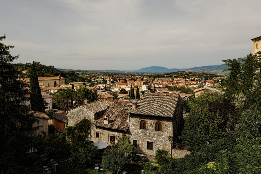 Spoleto dall'alto — I tetti della città vecchia tra gli ulivi, con la valle umbra sullo sfondo