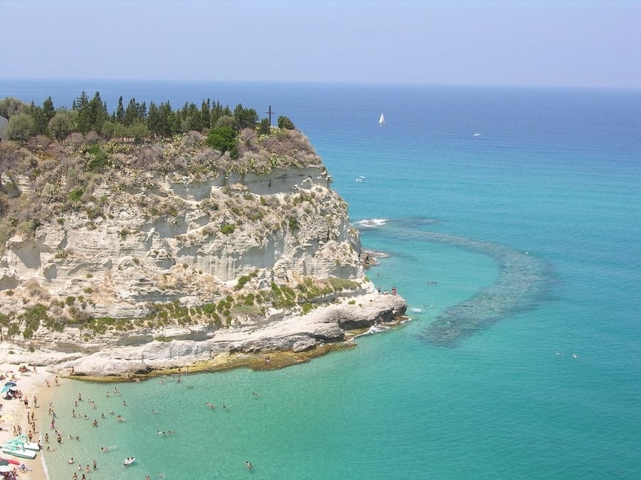 Spiaggia sotto la rupe — Sabbia chiara ai piedi della falesia su cui sorge il borgo antico